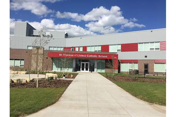 The front of St Therese of Lisieux Catholic School with a walkway leading to the entrance.